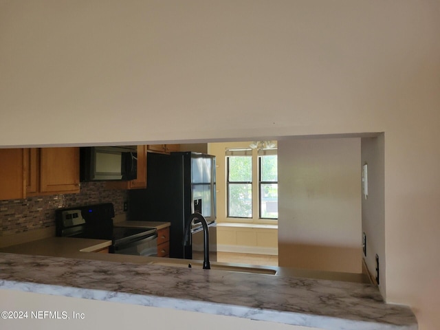 kitchen with black appliances, sink, and decorative backsplash