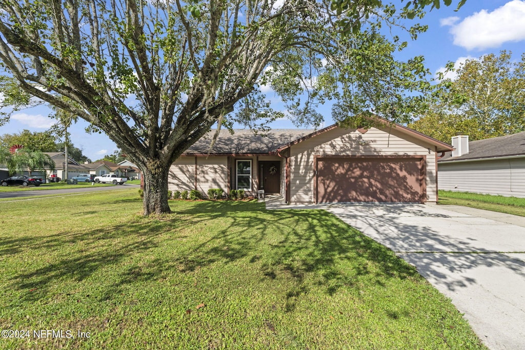 ranch-style house featuring a garage and a front yard