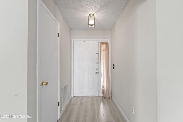 entryway featuring a textured ceiling and light wood-type flooring