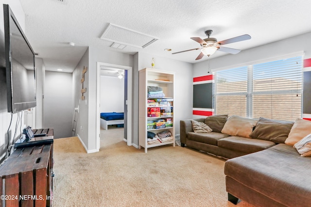 carpeted living room featuring ceiling fan and a textured ceiling