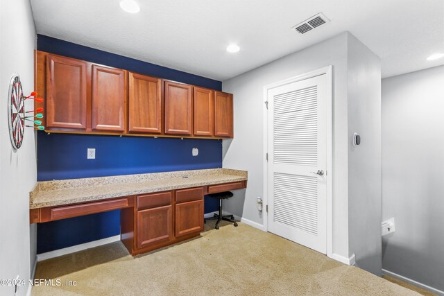 unfurnished office featuring light carpet and built in desk