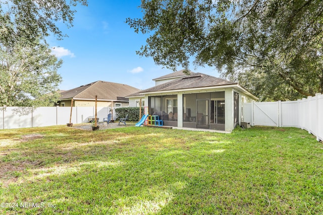 rear view of property with a yard and a sunroom