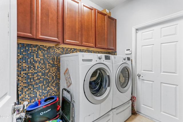 laundry area featuring cabinets and washing machine and dryer