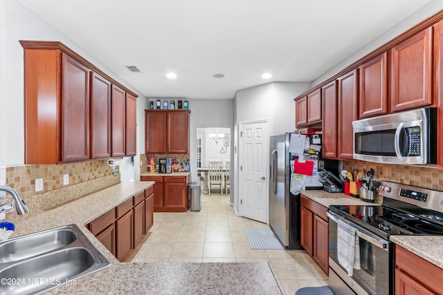 kitchen featuring light tile patterned flooring, appliances with stainless steel finishes, sink, and backsplash