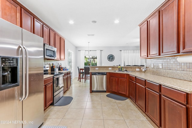 kitchen with sink, hanging light fixtures, stainless steel appliances, light stone counters, and kitchen peninsula