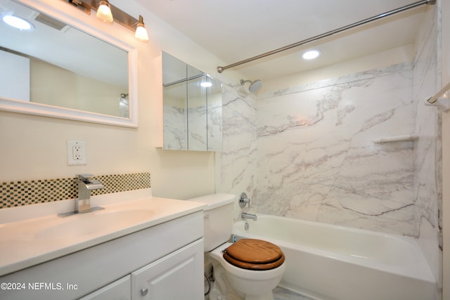 full bathroom featuring tiled shower / bath, vanity, and toilet