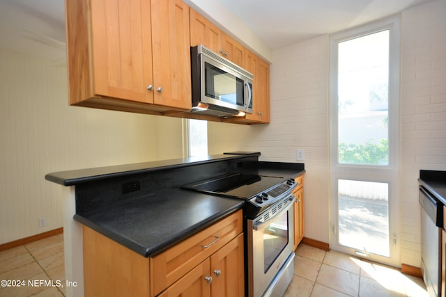 kitchen featuring light tile patterned flooring and stainless steel appliances