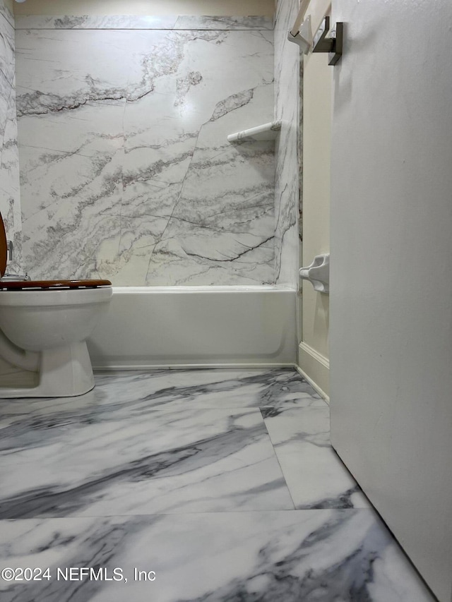 bathroom featuring toilet and tiled shower / bath