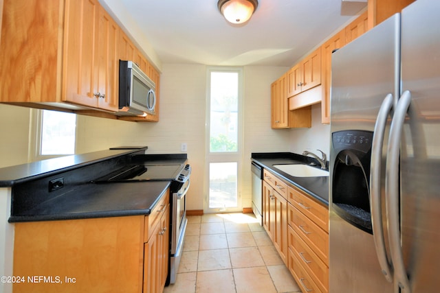 kitchen with decorative backsplash, appliances with stainless steel finishes, light tile patterned floors, and sink