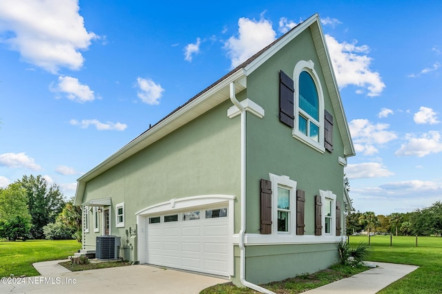 view of property exterior with central air condition unit, a garage, and a lawn