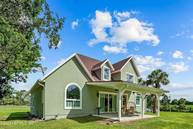 rear view of property featuring a patio area, a lawn, and ceiling fan