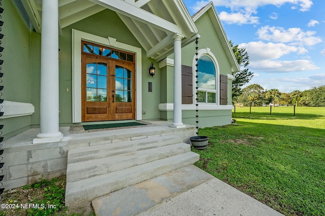 doorway to property featuring french doors and a lawn