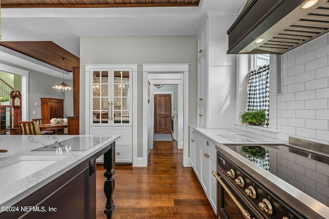 kitchen featuring dark wood-type flooring, decorative backsplash, white cabinetry, and custom range hood