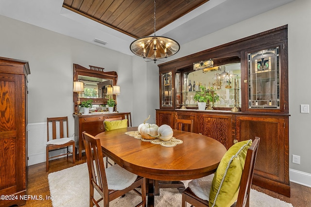 dining area featuring wood-type flooring, an inviting chandelier, and wood ceiling