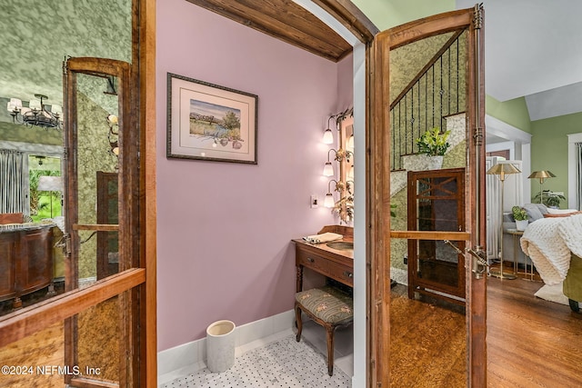 bathroom featuring lofted ceiling with beams and hardwood / wood-style floors