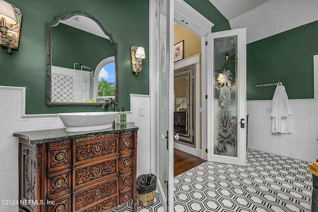 bathroom featuring hardwood / wood-style flooring, vanity, and tile walls