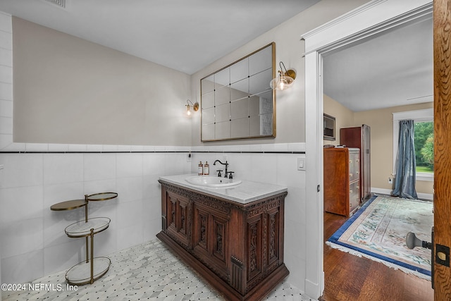 bathroom featuring vanity, hardwood / wood-style flooring, and tile walls