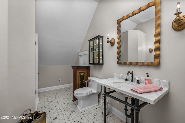 bathroom with lofted ceiling, sink, and toilet