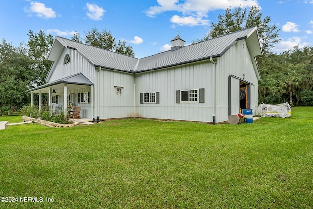 view of side of home featuring a lawn and covered porch