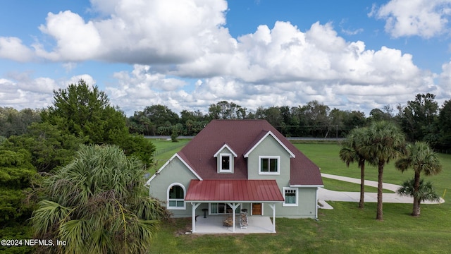 rear view of house with a patio and a lawn