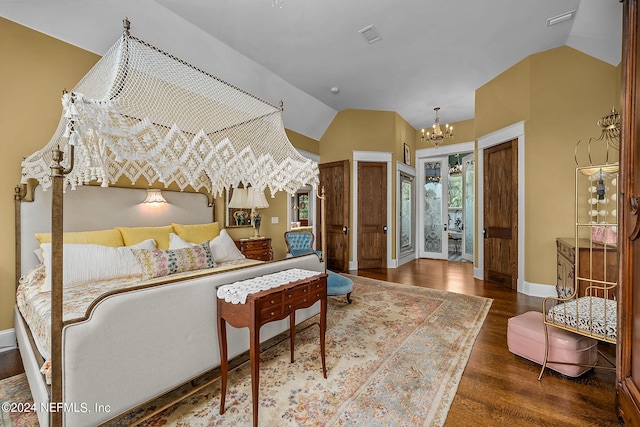 bedroom with lofted ceiling, ensuite bath, dark wood-type flooring, and an inviting chandelier