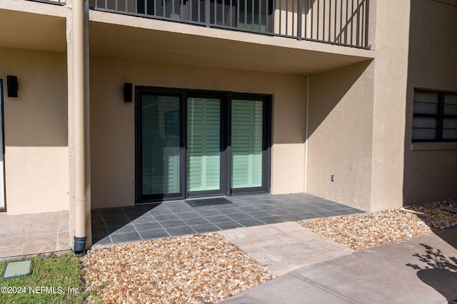 view of exterior entry featuring a balcony