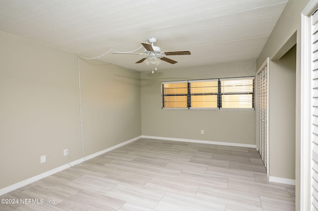 unfurnished bedroom with ceiling fan and a textured ceiling