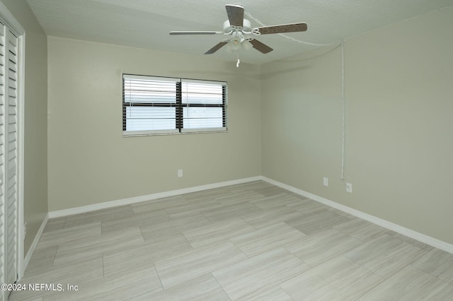 spare room featuring ceiling fan and a textured ceiling