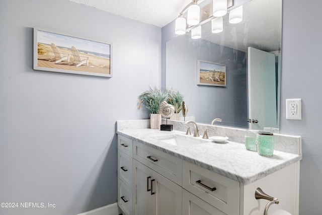 bathroom featuring a textured ceiling and vanity