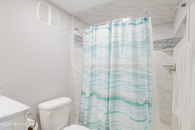 bathroom featuring a shower with curtain, vanity, and toilet