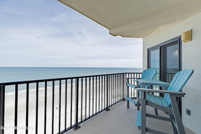 balcony featuring a beach view and a water view