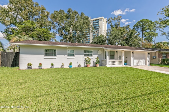 ranch-style house featuring a front lawn, covered porch, and a garage