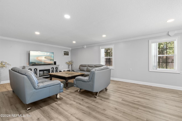 living room featuring a textured ceiling, a healthy amount of sunlight, light hardwood / wood-style floors, and ornamental molding