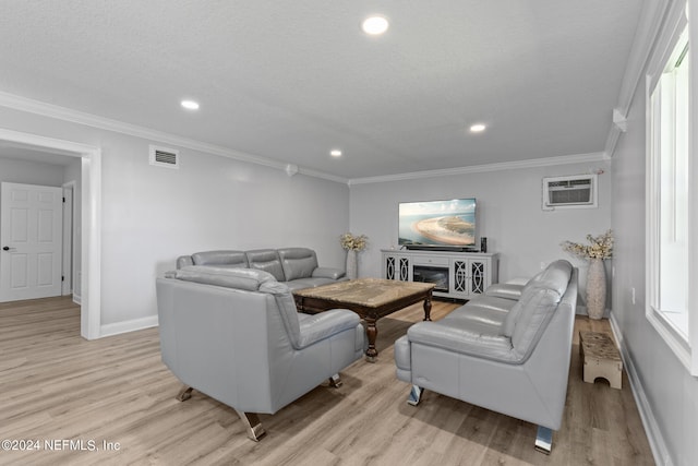 living room featuring a textured ceiling, light wood-type flooring, crown molding, and an AC wall unit