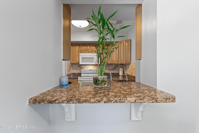 kitchen featuring decorative backsplash, white appliances, and sink