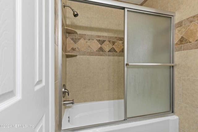 bathroom featuring bath / shower combo with glass door