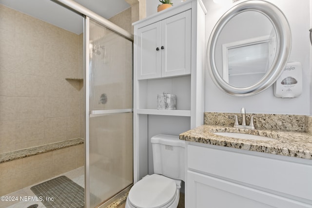 bathroom featuring vanity, toilet, and an enclosed shower