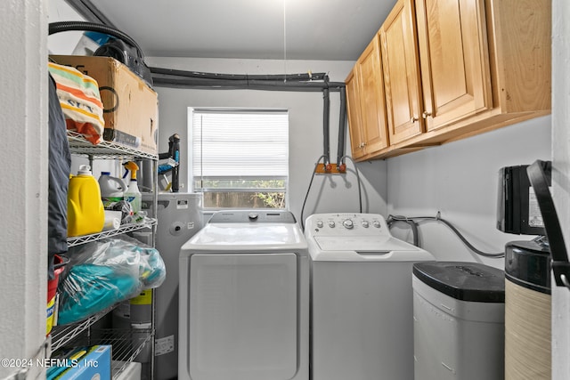 laundry area with washing machine and dryer, gas water heater, and cabinets