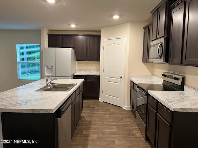 kitchen featuring a textured ceiling, dark hardwood / wood-style floors, a kitchen island with sink, sink, and stainless steel appliances