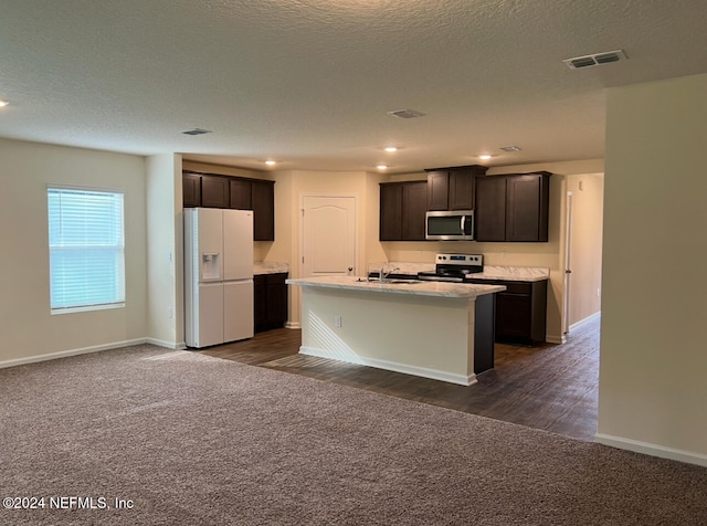 kitchen featuring appliances with stainless steel finishes, dark brown cabinetry, dark hardwood / wood-style floors, and an island with sink