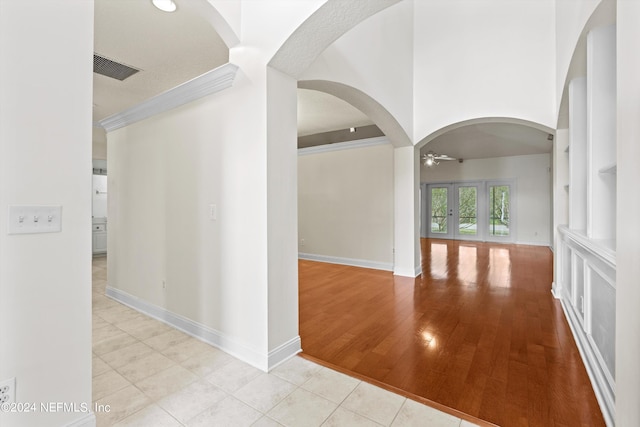 hallway with french doors, light hardwood / wood-style flooring, and ornamental molding