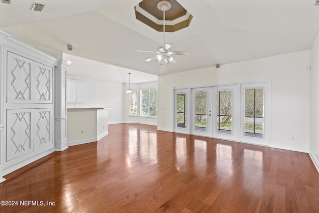 unfurnished living room featuring ceiling fan, a textured ceiling, french doors, and dark wood-type flooring