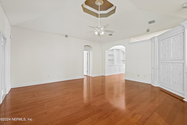 unfurnished living room featuring ceiling fan, built in features, and hardwood / wood-style flooring