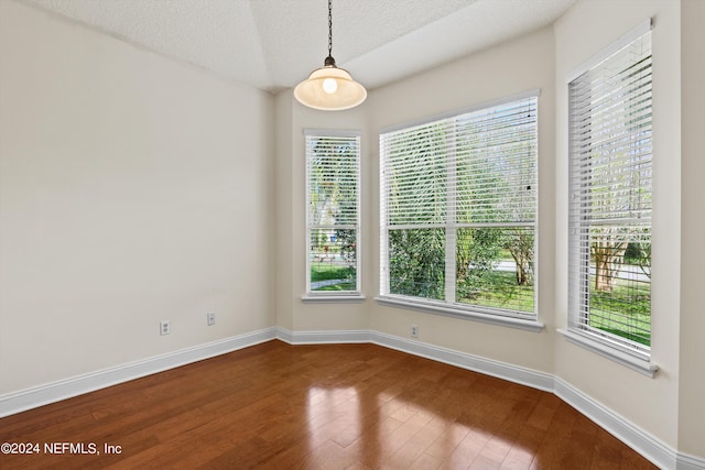 empty room with a textured ceiling and hardwood / wood-style floors