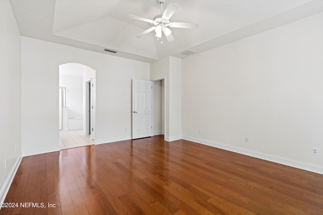 unfurnished bedroom featuring light wood-type flooring, ensuite bath, ceiling fan, and a textured ceiling