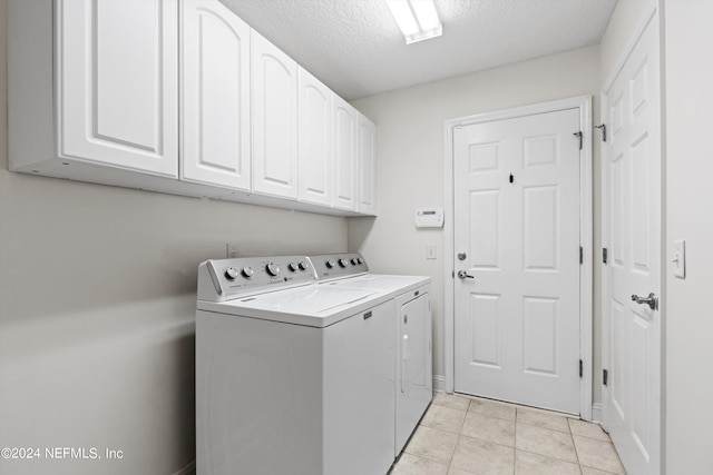 washroom with cabinets, a textured ceiling, light tile patterned flooring, and separate washer and dryer