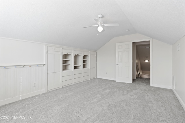 bonus room featuring a textured ceiling, lofted ceiling, ceiling fan, and light colored carpet