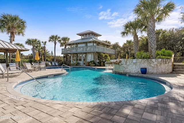 view of swimming pool featuring pool water feature and a patio area