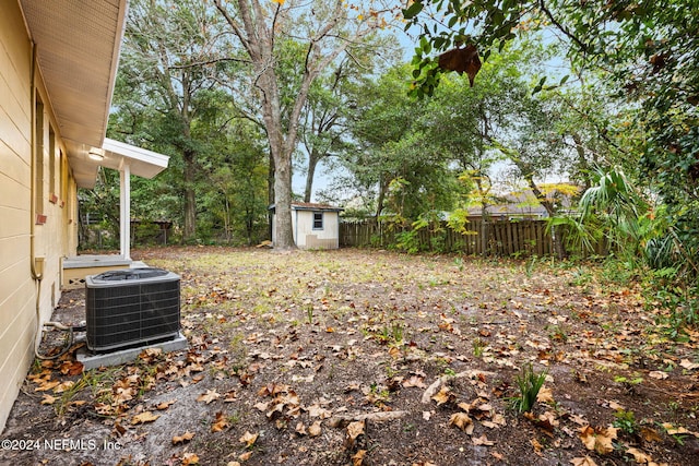 view of yard with central AC unit and a storage unit