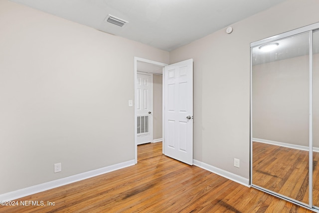 unfurnished bedroom with hardwood / wood-style floors and a closet